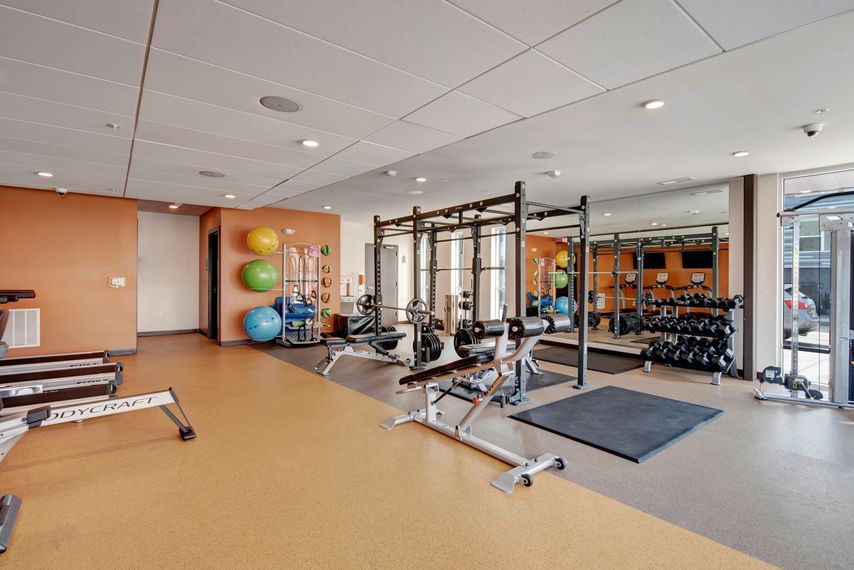 A large gym with a lot of equipment and a lot of mirrors.