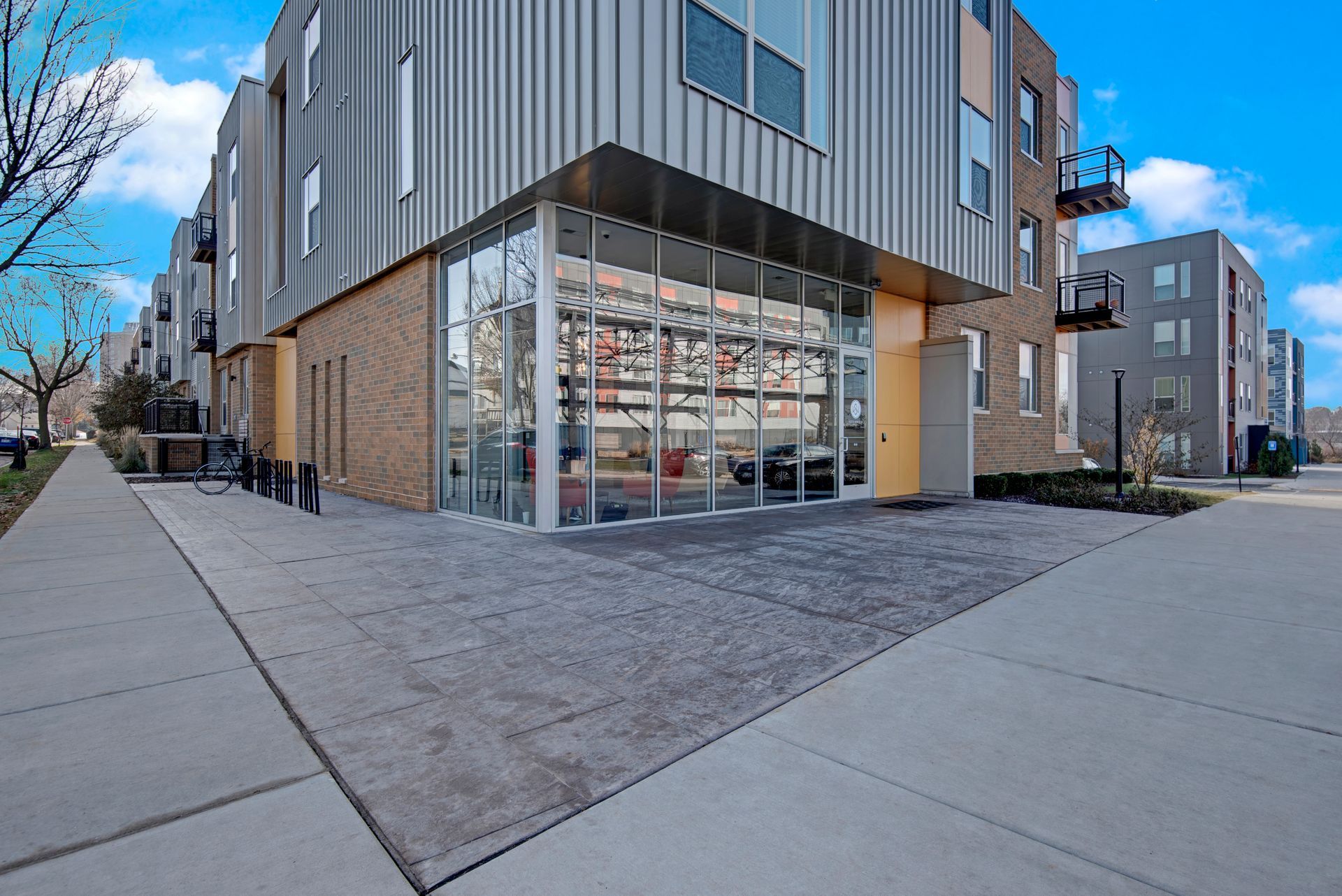 A large building with a lot of windows and a sidewalk in front of it.
