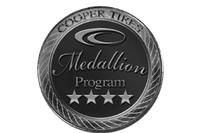 A black and white photo of a medallion from cooper tires.