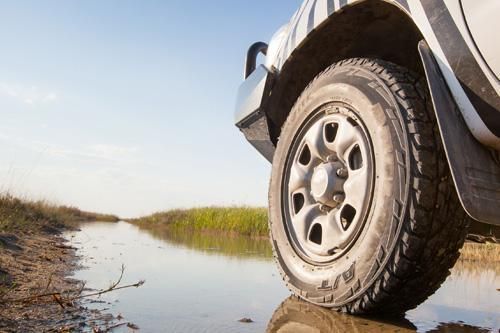 A truck is driving through a muddy river.