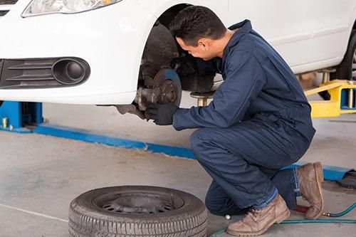 A man is working on a car in a garage.