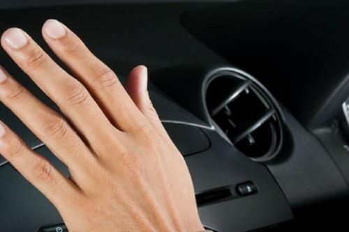 A close up of a person 's hand on the dashboard of a car