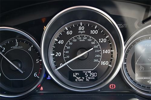 A close up of a car 's dashboard with a speedometer and a temperature gauge