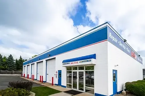 A white and blue building with a lot of garage doors.