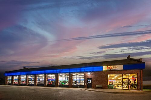 A brick building with a blue awning and a sign that says ' jc ' on it