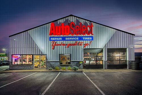 A large metal building with a sign that says auto select repair service tires.