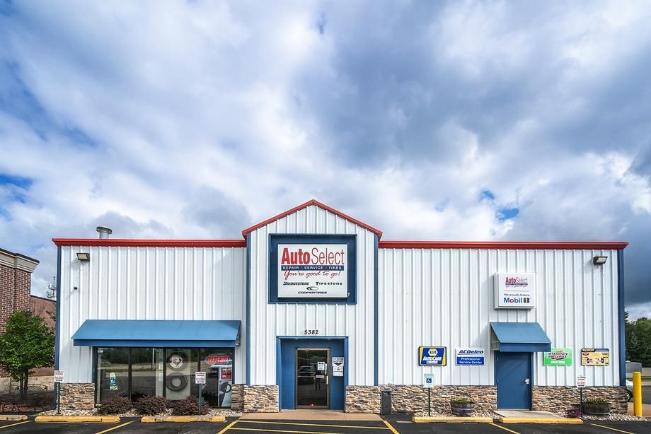 A white building with a red roof and a blue awning.