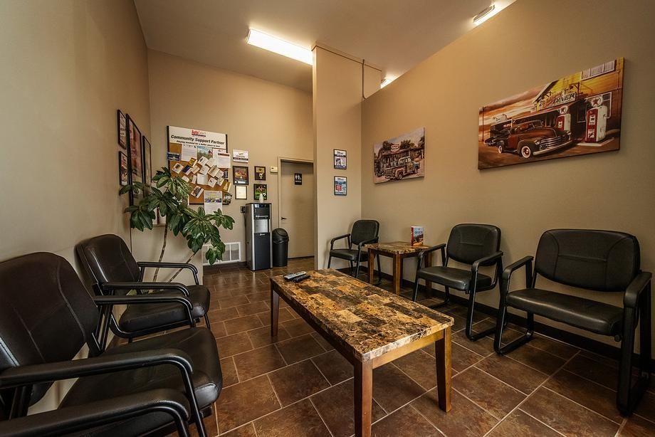 A waiting room with chairs , tables and a coffee table.