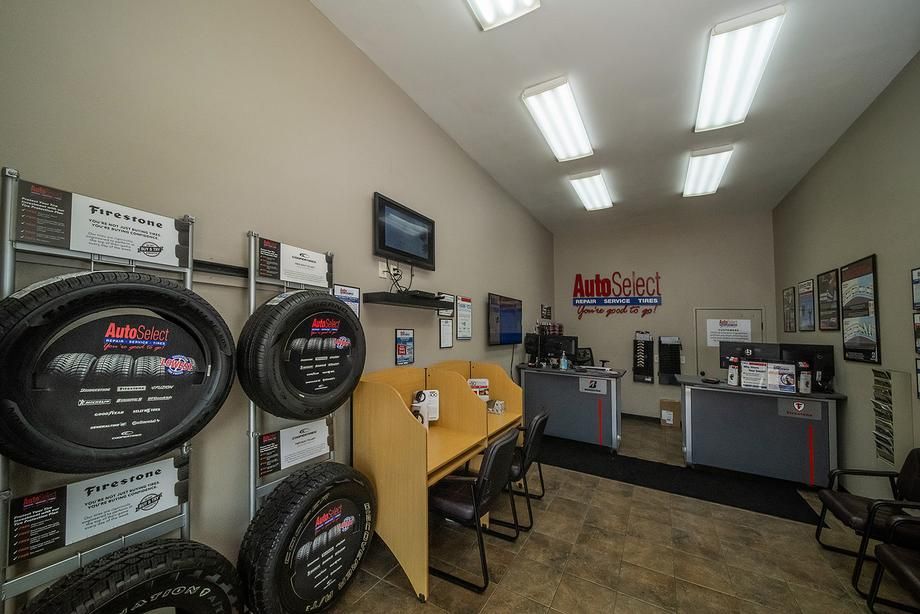 A room with a lot of tires on display and a desk.