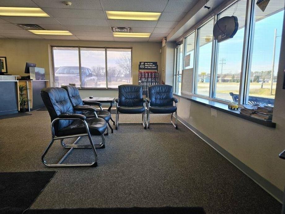 A waiting room with a lot of windows and chairs