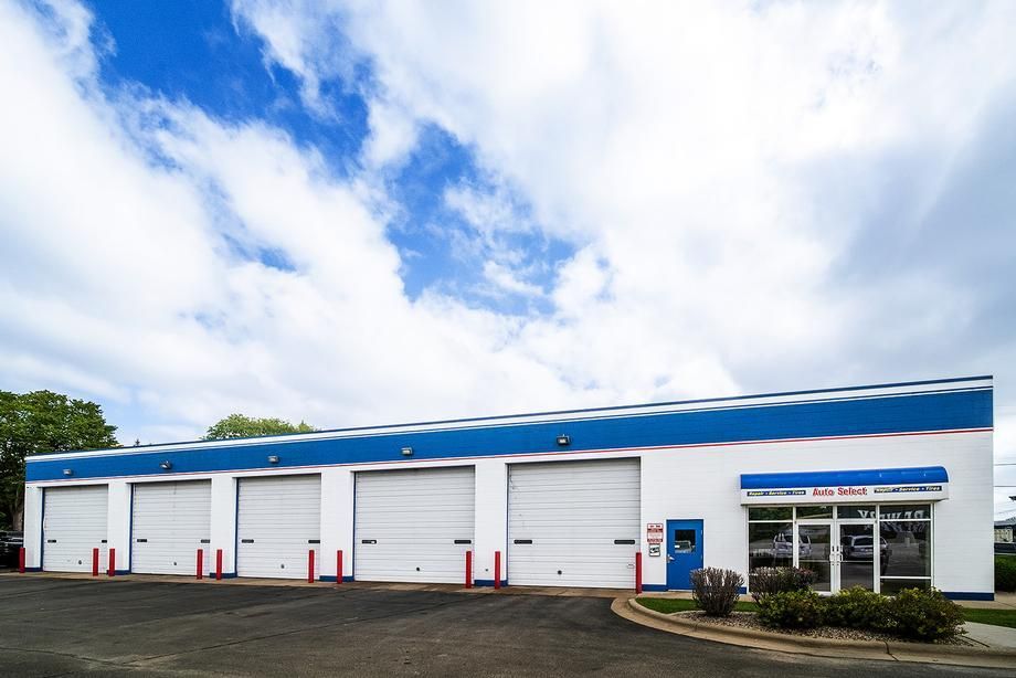 A white and blue building with a lot of garage doors
