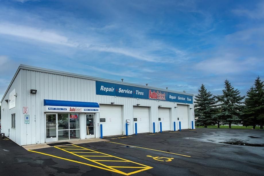 A white and blue building with a handicapped parking spot in front of it.