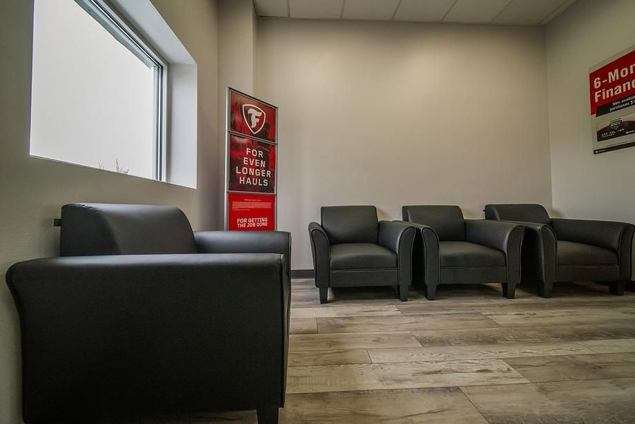 A waiting room with chairs and a sign on the wall.