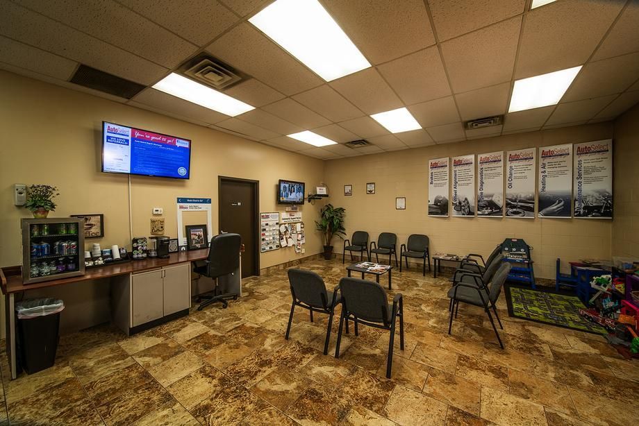 A waiting room with chairs and a tv on the wall