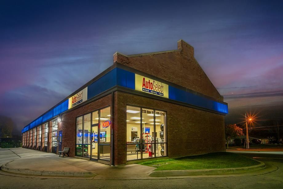 A large brick building with a blue awning is lit up at night.