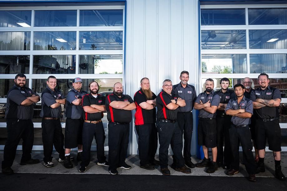 A group of men are posing for a picture in front of a garage door.