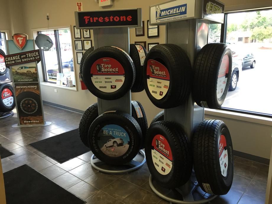 A display of tires in a tire store with a sign that says firestone
