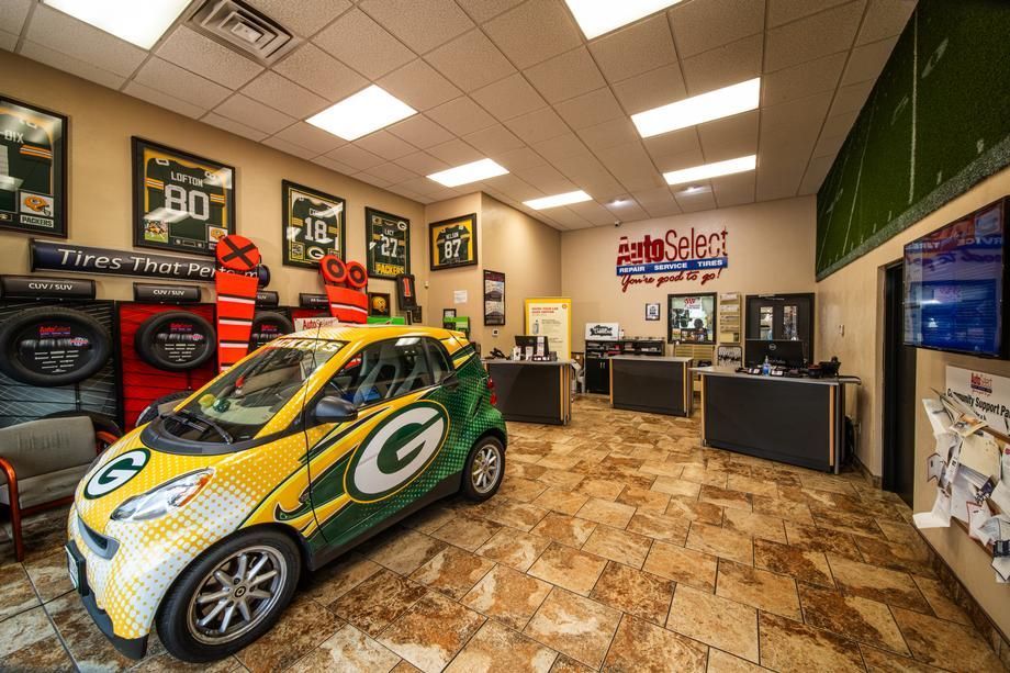 A green bay packers car is parked in a car dealership.