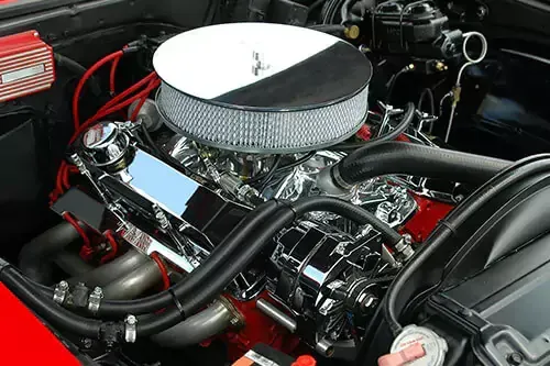 A close up of a car engine with a air filter