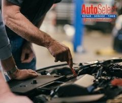 A man is working on the engine of a car in a garage.