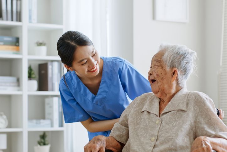 woman, nurse, caregiver, carer of nursing home talking with senior Asian woman feeling happy at home