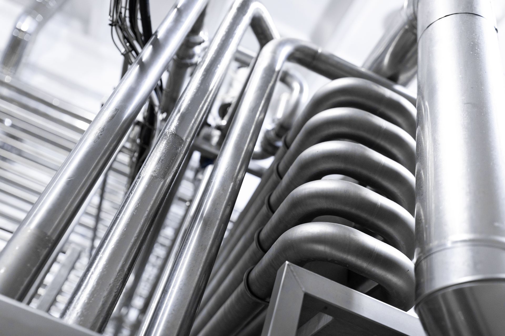 A bunch of stainless steel pipes are stacked on top of each other