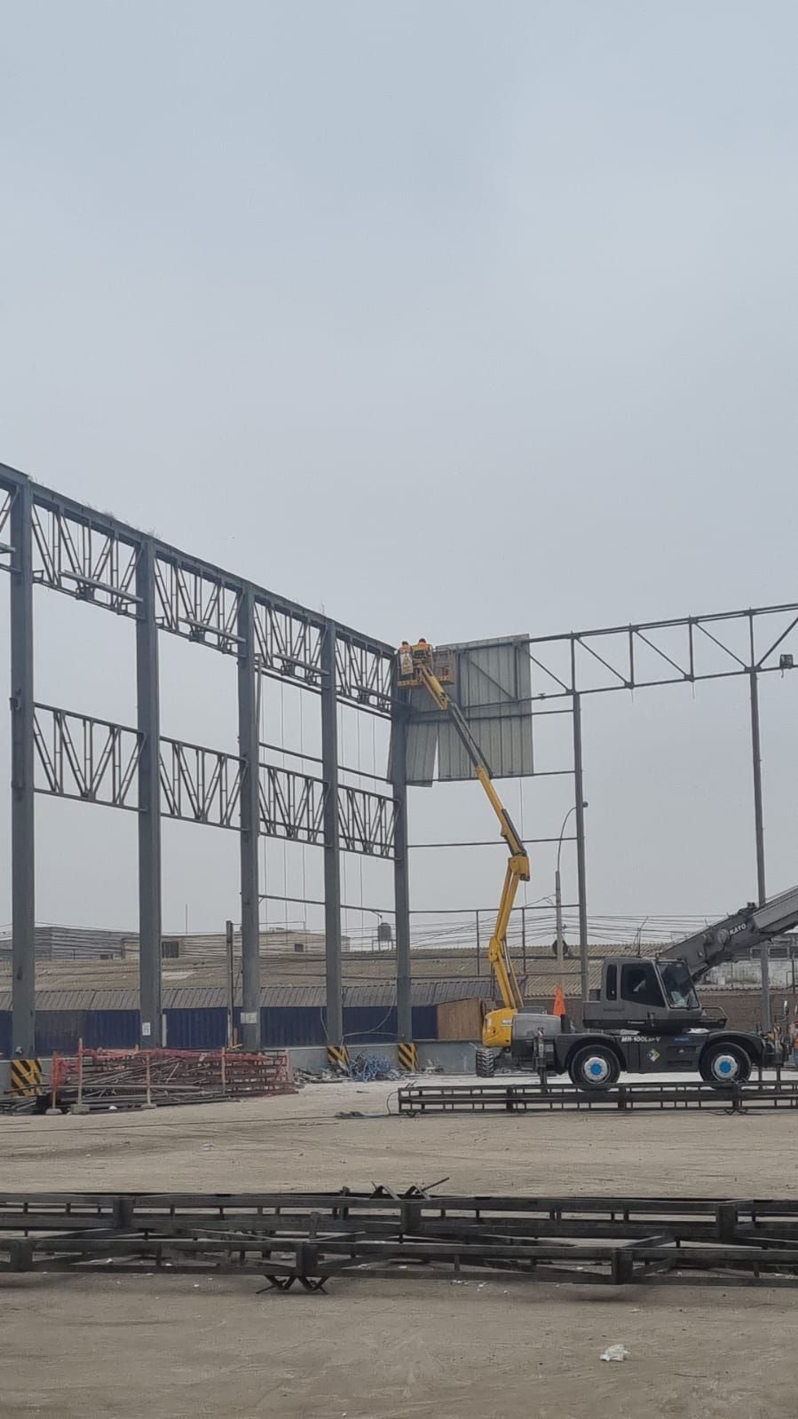 Obreros de la construcción utilizando una grúa para instalar un panel en una estructura