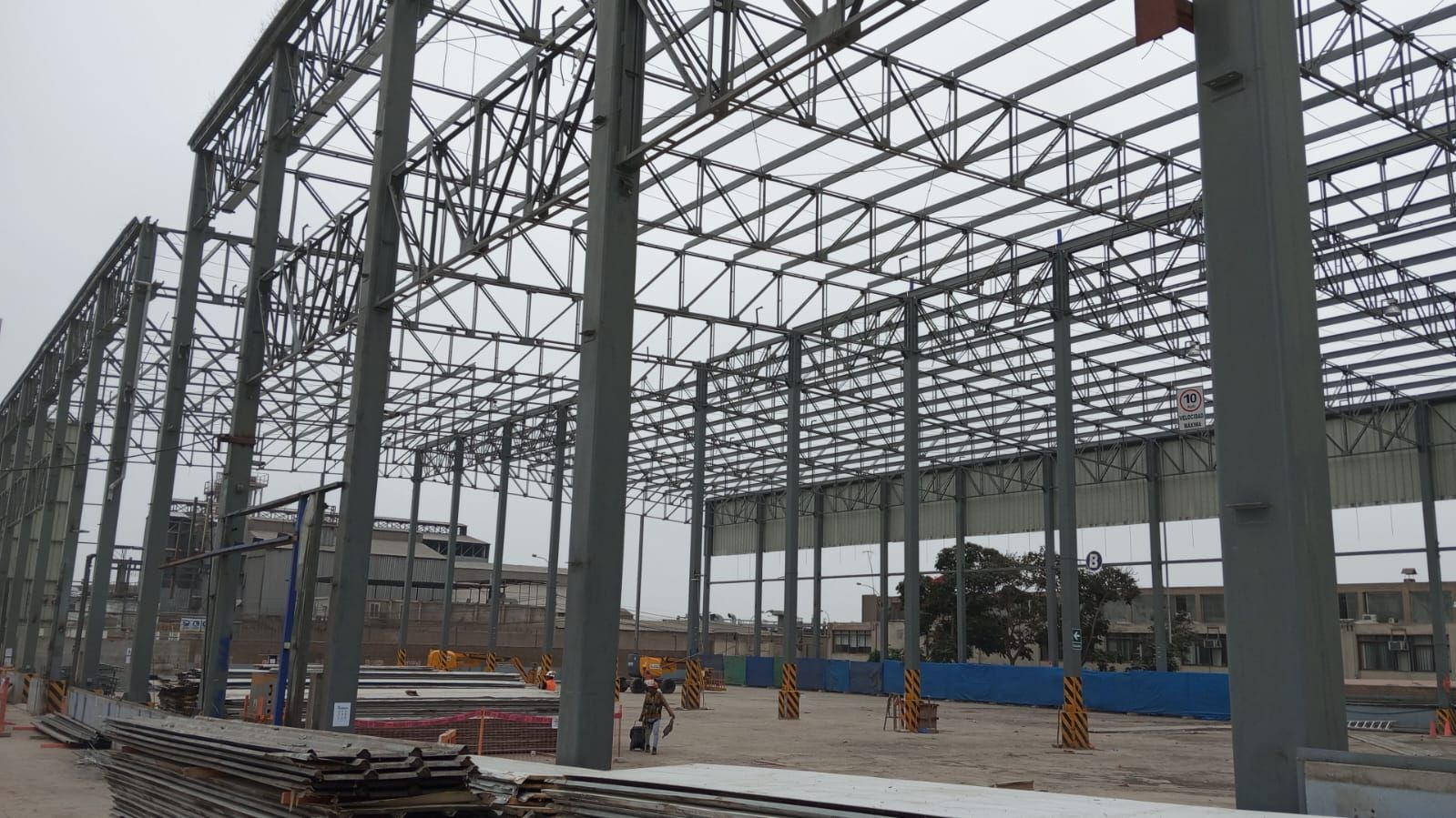 Estructura de acero de un gran edificio en construcción contra un cielo nublado.