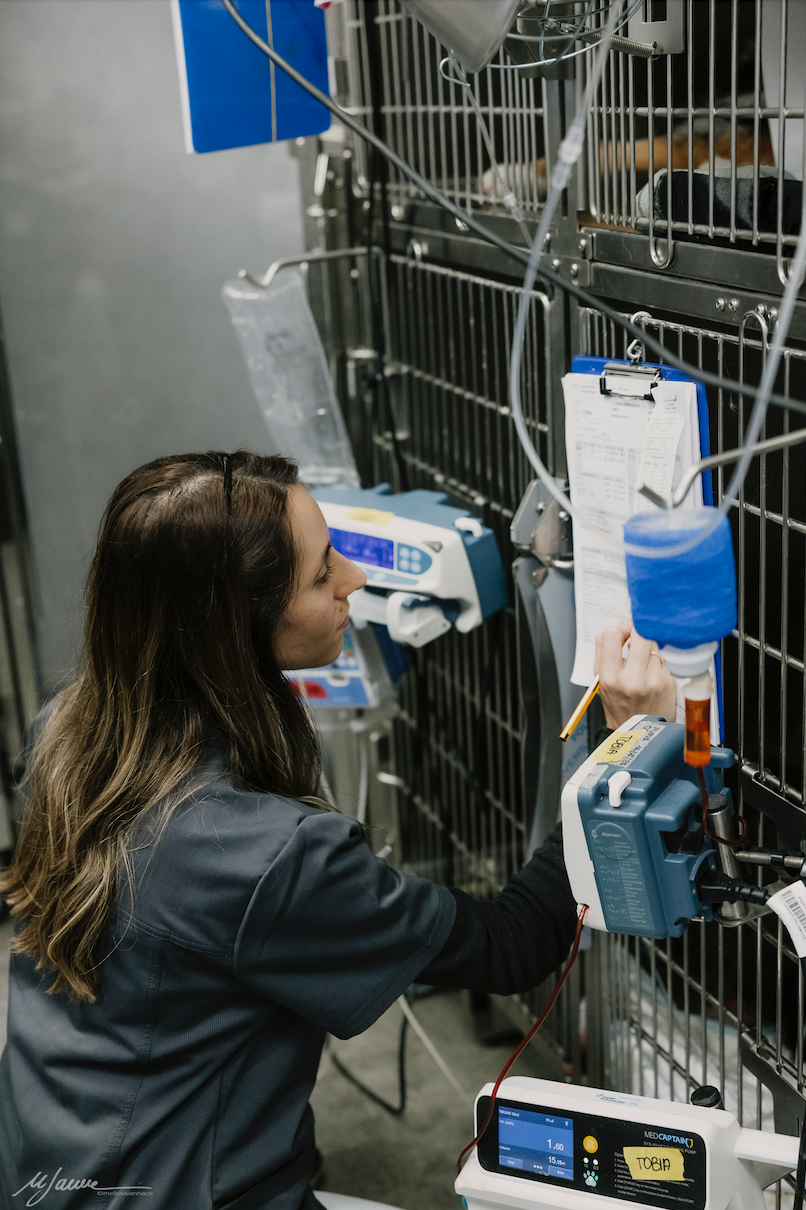 Uomo con camicia blu, occhiali, macchinari in funzione, ambiente buio.