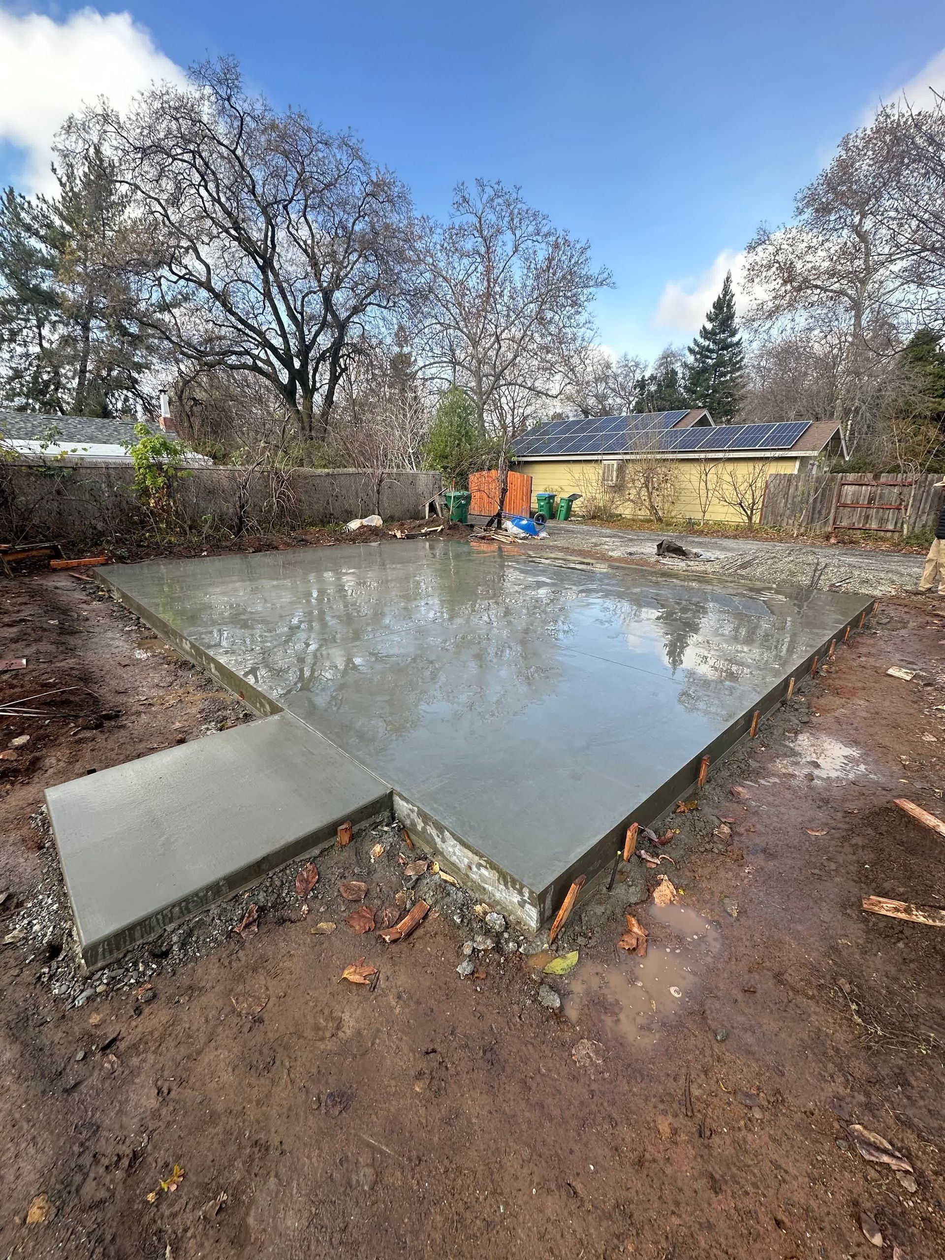 A man is using a trowel to spread concrete on a construction site.