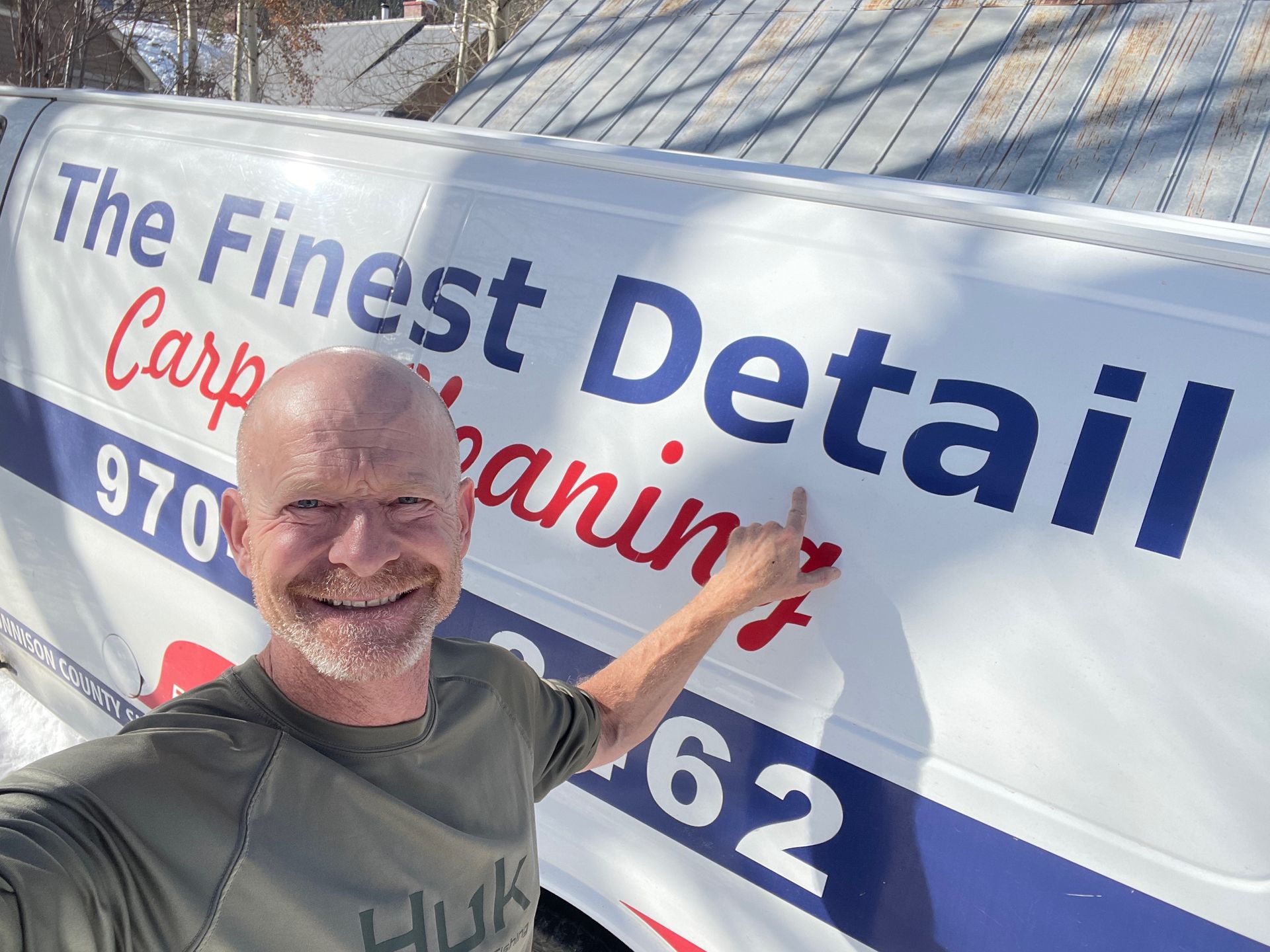 A man is standing in front of a van that says the finest detail carp cleaning company