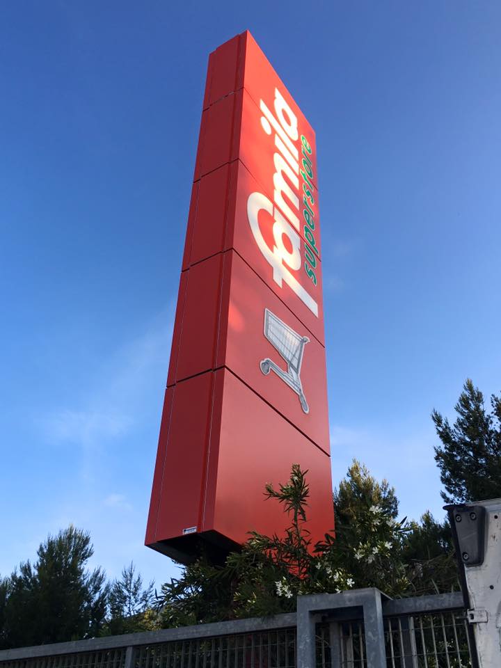 una colonna rossa con scritto Famiglia Supermercato