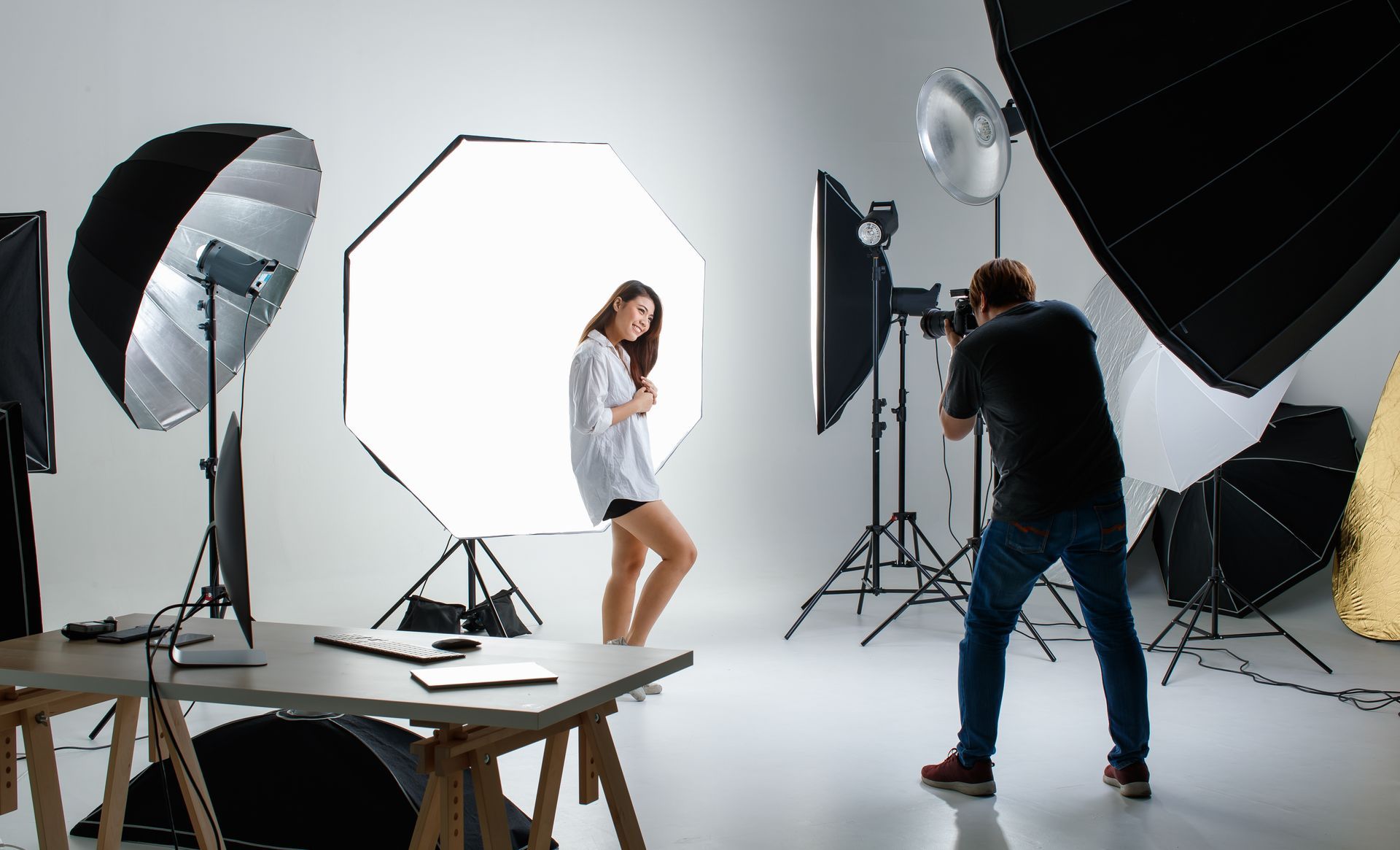 A man is taking a picture of a woman in a photo studio.