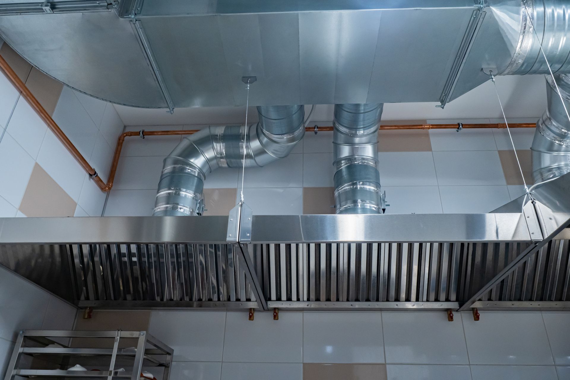 Hotte de cuisine commerciale en acier inoxydable avec conduits.