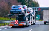 Car carrier truck loaded with vehicles on a highway.