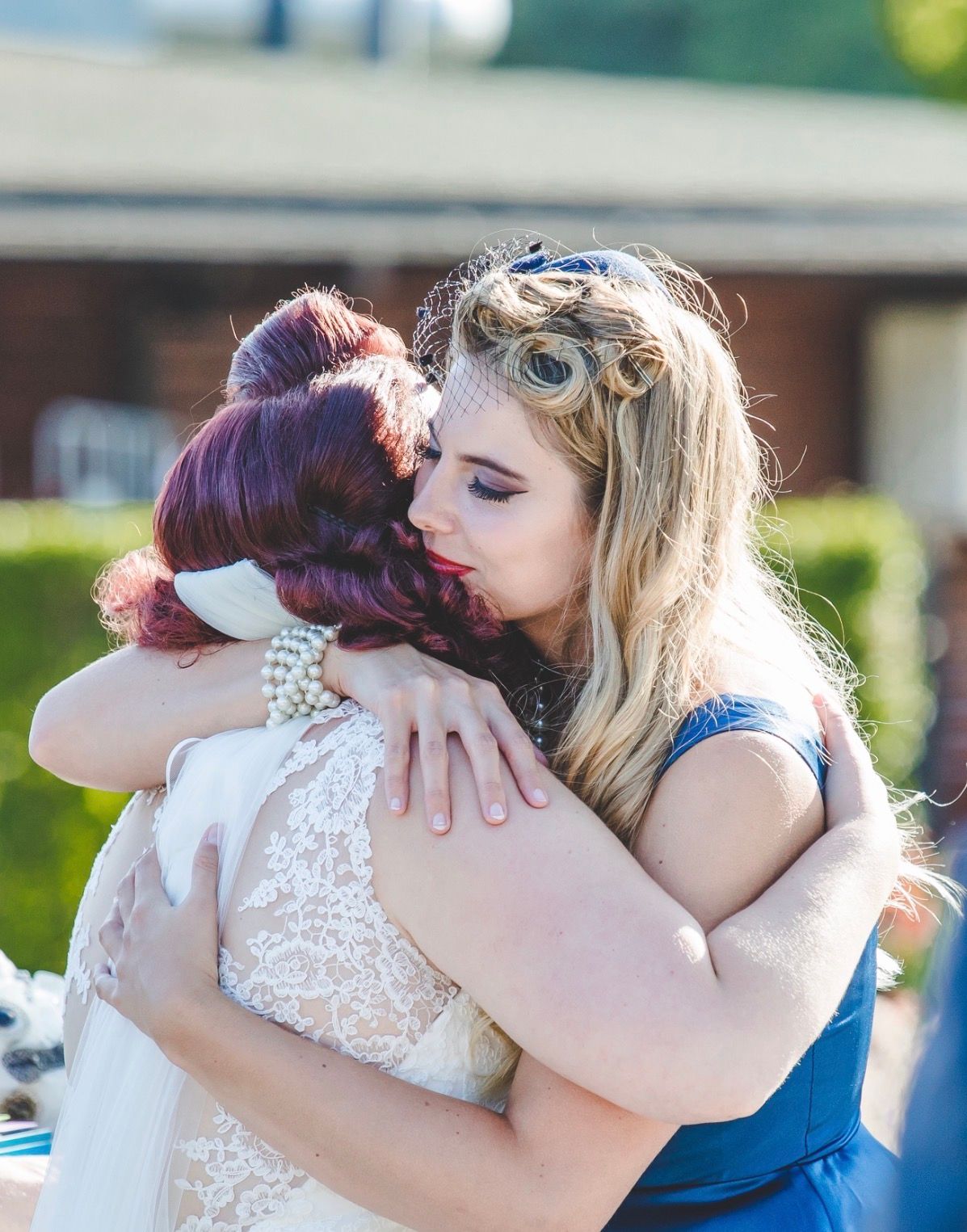 Vrouw met roze hoed en jurk met patroon op een grote buitentrap.