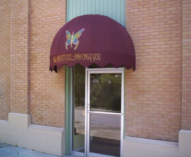 Burgundy awning over a glass door, with a butterfly and 