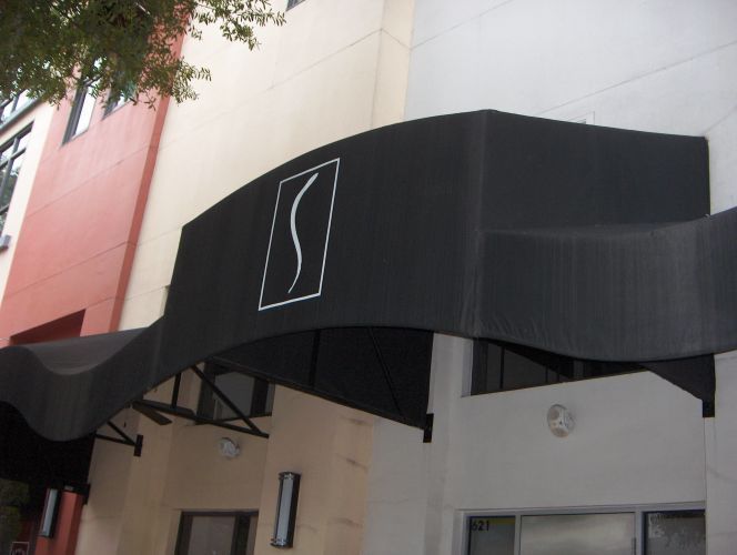 Black awning over a building entrance, with a white 
