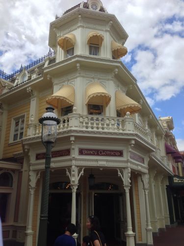 Dapper Dan's barbershop in Disneyland, two-story Victorian-style building with awnings and a streetlamp.