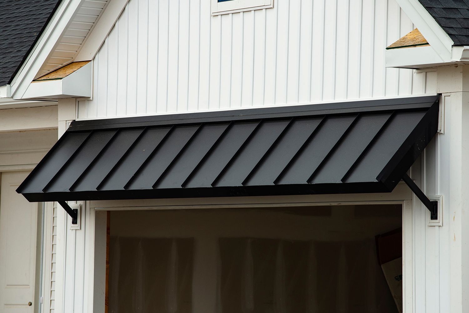 Modern black awning above a garage door, designed for durability and style in outdoor spaces.