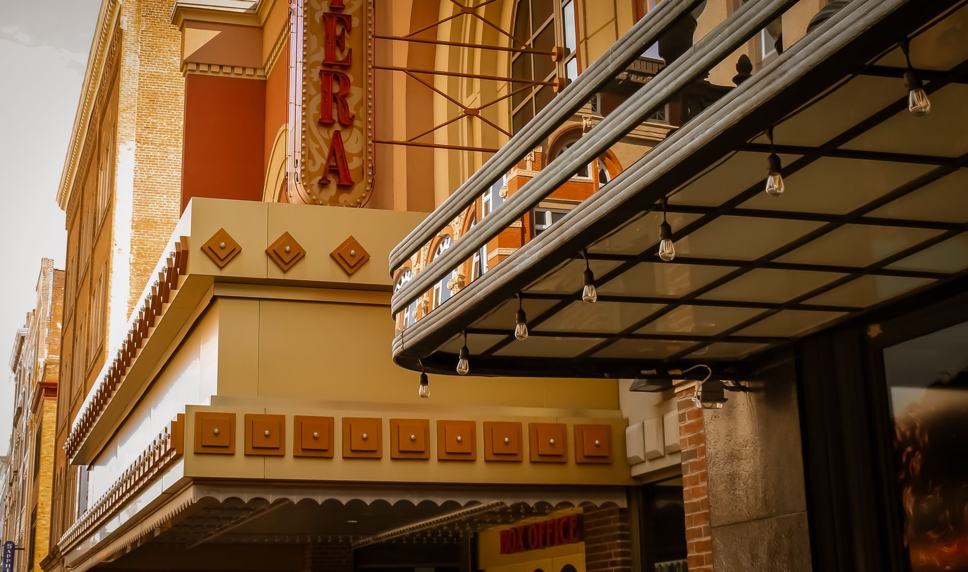 Exterior of an old theater with marquee, lights, and