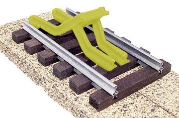Yellow rail maintenance machine on train tracks beside gravel ballast and wooden ties