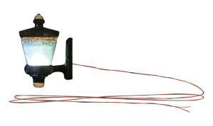 Old-fashioned black wall lantern with a glowing white light and a trailing red electrical cord