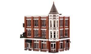 Red-brick Victorian-style corner building with a pointed turret and white trim on a plain white background