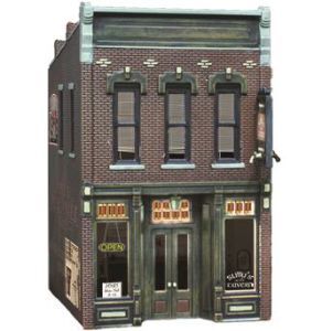 Miniature brick storefront with green doors and windows, resembling a vintage downtown building.