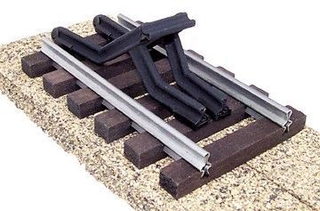 Railroad track switch mechanism with black lever assembly and silver rails on gravel ballast