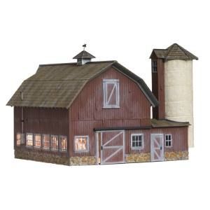 Small red barn with a tall silo and lofted roof on a white background