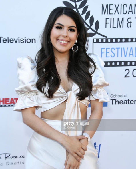 A woman stands on a red carpet at the mexican film festival