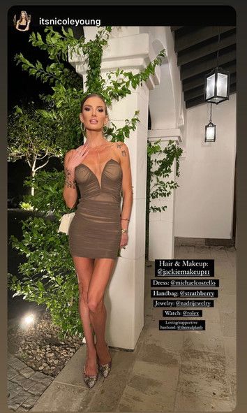 A woman in a brown dress is standing next to a white pillar.