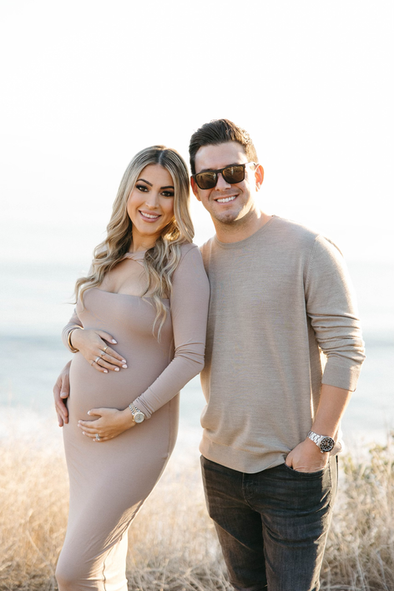 A man and a pregnant woman are posing for a picture.